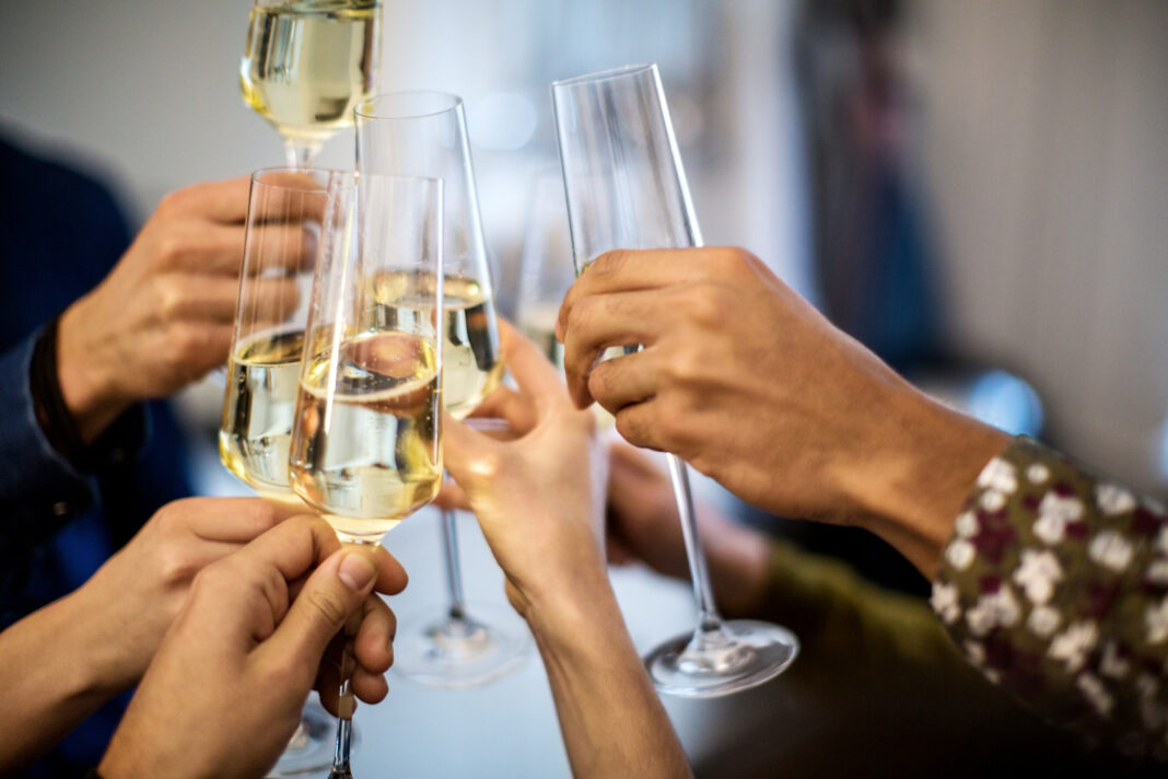 Hands toasting champagne flutes during dinner party