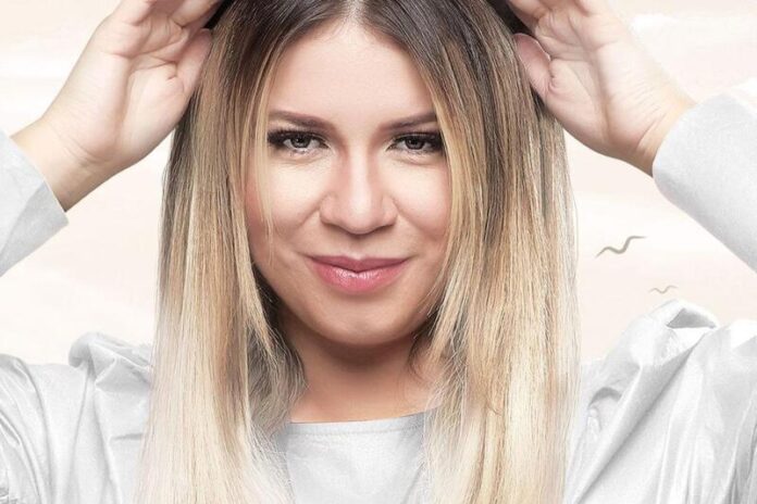 marilia-mendonca-posando-seria-em-cartaz-com-look-branco