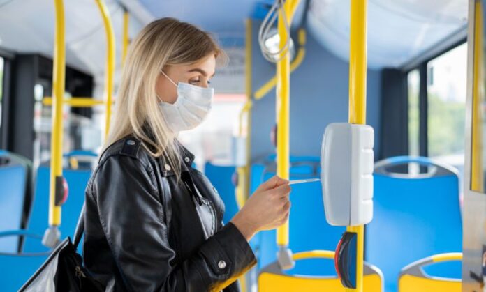 woman-traveling-by-public-bus-wearing-medical-mask-protection-using-bus-pass-780x470