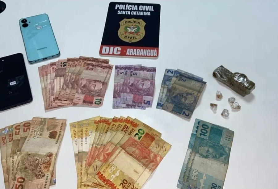 Material apreendido pela Polícia Civil de Araranguá (DIC): dinheiro em notas de Real (R$ 100, R$ 50, R$ 20, R$ 10, R$ 5, R$ 2), celulares e porções de drogas.