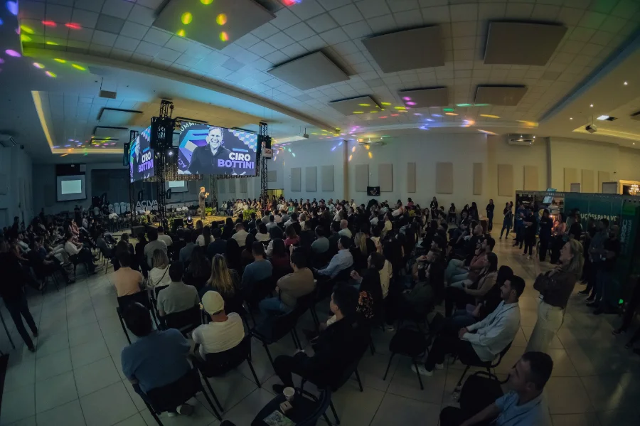 Palestrante Ciro Bottini em palco, falando para um grande público no FAN Summit da ACIVA, realizado em Araranguá.