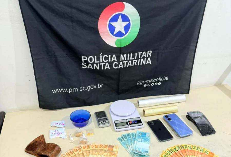 Material apreendido pela Polícia Militar de Santa Catarina: balanças de precisão, celulares, dinheiro em notas de Real e embalagens plásticas, ilustrando a prisão por tráfico de drogas em Araranguá.