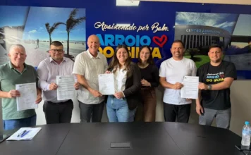 Arroio do Silva assina ordens de serviço para R$ 3 milhões O prefeito Evandro Scaini e outras autoridades em uma mesa, assinando as ordens de serviço para a pavimentação da Rua João Manoel Coelho e o novo Parque Farroupilha.