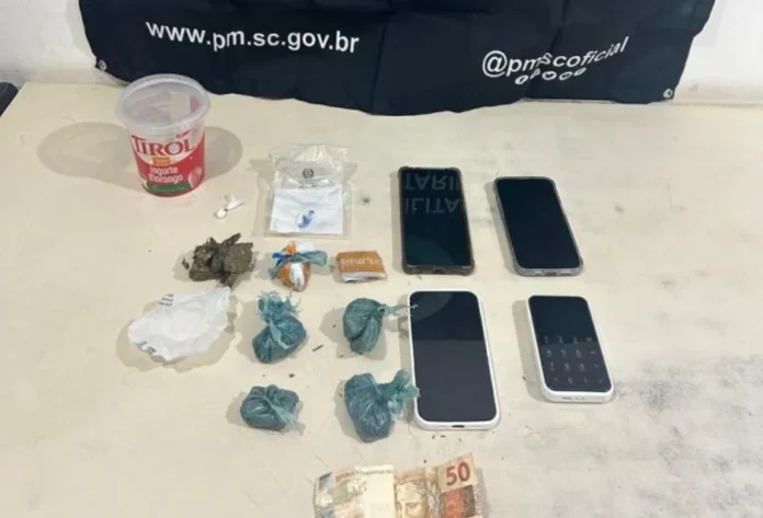 Casal é preso em flagrante por tráfico de drogas em Sombrio Material apreendido pela Polícia Militar em Sombrio: pacotes de drogas (entorpecentes), quatro celulares e dinheiro, em flagrante de tráfico de drogas.