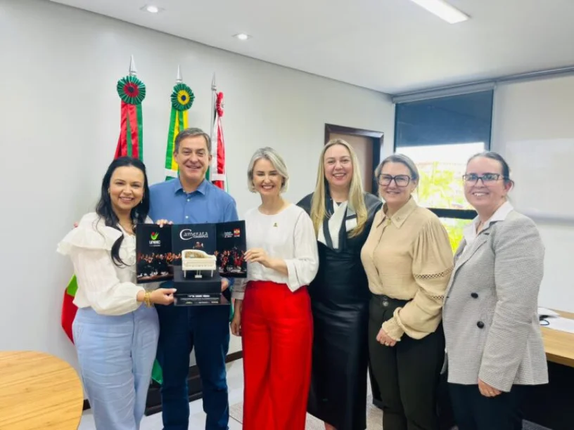 Representantes da UNESC e autoridades recebem o material promocional da Camerata, um presente da Universidade para o Centenário de Criciúma.