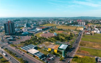 Centenário de Criciúma terá show, feira e inaugurações Vista aérea da cidade de Criciúma em um dia ensolarado, mostrando a área urbana, prédios e o Parque Centenário ao centro, em celebração aos 100 anos do município.