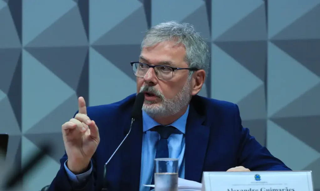 Ex-diretor do INSS nega elo com políticos, mas confessa indicação Ex-diretor do INSS, Alexandre Guimarães, com barba e óculos, discursando em depoimento na CPMI, onde negou elo com políticos, mas admitiu indicação política.