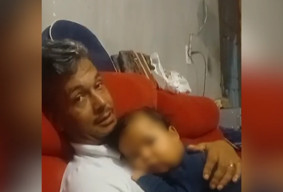 Família em Araranguá clama por ajuda após corte de benefício O pai, Rodrigo, segura seu filho de seis meses no colo, em Araranguá, no apelo por ajuda após o corte de seu benefício.