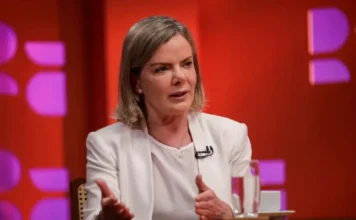 Gleisi critica “Consórcio da Paz” de governadores de direita Ministra Gleisi Hoffmann, vestindo blazer branco, discursando em entrevista, criticando a aliança de governadores de direita (Consórcio da Paz) e seu impacto na política nacional.