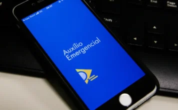 Governo cobra R$ 478,8 mi por auxílio emergencial indevido Tela de smartphone com o aplicativo Auxílio Emergencial, ilustrando o tema de pagamentos ou cobranças indevidas.