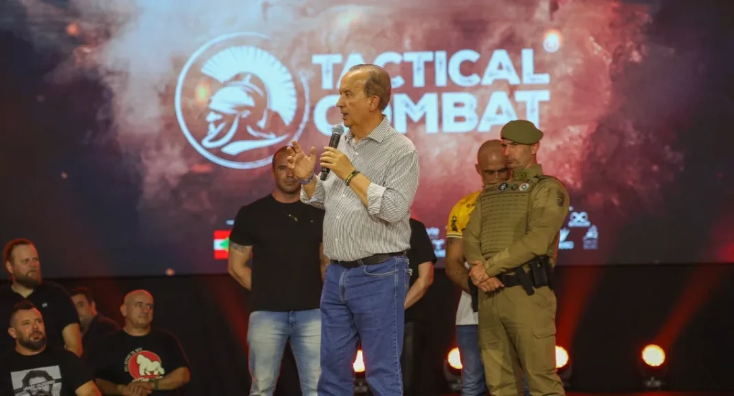 Jorginho Mello participa do Tactical Combat em Criciúma Governador Jorginho Mello discursando no palco do evento Tactical Combat em Criciúma, ladeado por policiais e organizadores.