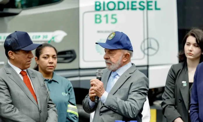 Lula debate com CEOs inclusão de biocombustíveis na exportação Presidente Lula discursando em frente a um caminhão com o logo "BIODIESEL B15", em reunião com CEOs para debater a inclusão de biocombustíveis na pauta de exportação brasileira.