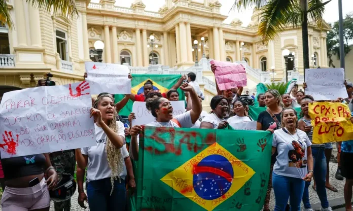 Lula sanciona lei que pune obstrução e fortalece combate ao crime Grupo de mulheres protestando com cartazes e a bandeira nacional, em contexto de clamor por justiça e combate ao crime.