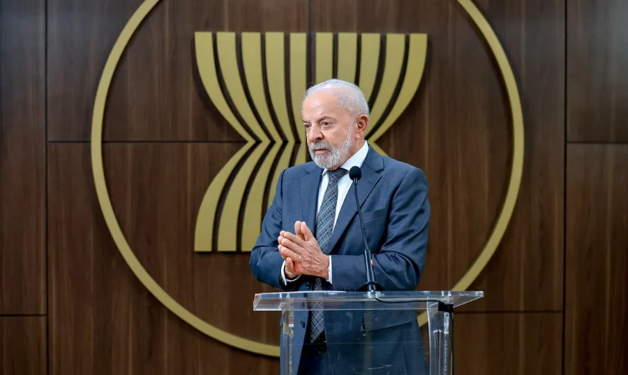 Lula vai debater com Trump punição a ministros do STF Presidente Lula discursando em púlpito, com o logo da ASEAN ao fundo, em meio a debates sobre política externa e punição a ministros do STF.