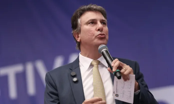 Ministro Camilo Santana defende salário digno no Dia do Professor Ministro da Educação Camilo Santana discursando em um evento, com microfone em mãos, defendendo o salário digno para professores no Dia do Professor.