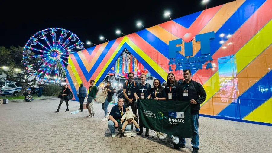 Missão do Sebrae SC leva Georrota dos Cânions à Buenos Aires Um grupo de 12 empresários e representantes do Sebrae/SC em frente ao banner da FIT Buenos Aires 2025, na área externa do evento.