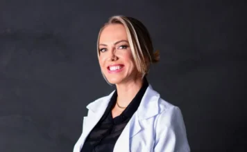 Nutrição com propósito: cuidando do corpo, nutrindo a alma Profissional de nutrição, Ana Paula Sartor Ronconi, vestindo jaleco e sorrindo, ilustrando o conceito de 'Nutrição com propósito' e cuidado integral do corpo e da alma.