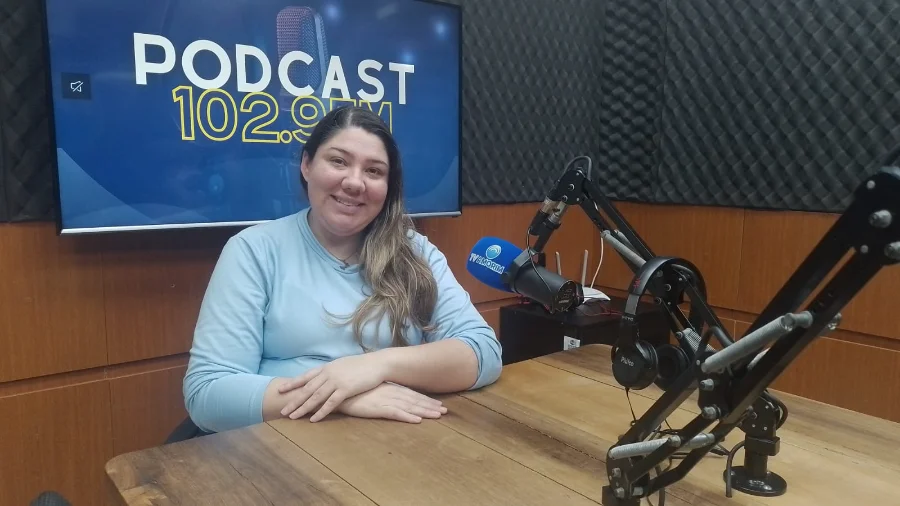 Dra. Morgana Costa, da Oral Unic de Sombrio, sorrindo em estúdio, sendo entrevistada no Podcast 102.9 FM sobre implante dentário sem contraindicação de idade.