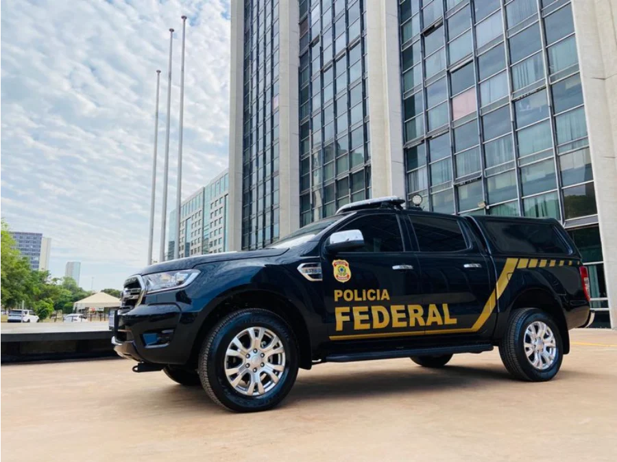 PF prende suspeitos de fraudar concursos em três estados Uma ilustração digital de uma viatura da Polícia Federal (PF), com a porta aberta, simbolizando a deflagração da Operação Última Fase de combate às fraudes em concursos públicos.