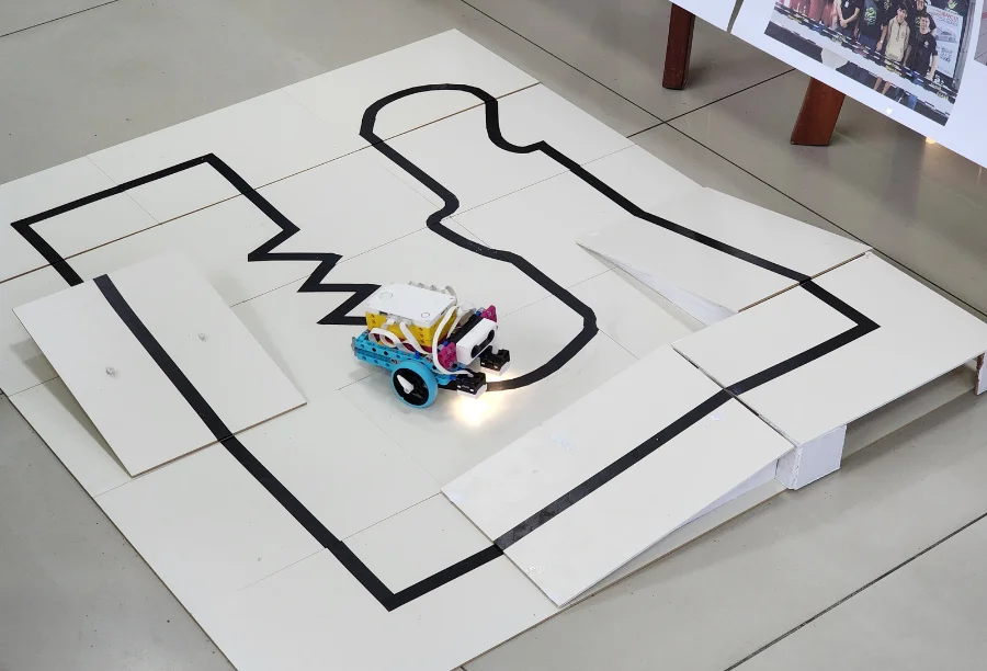 Alunos do Polo de Altas Habilidades e professoras em exposição de robótica no shopping.