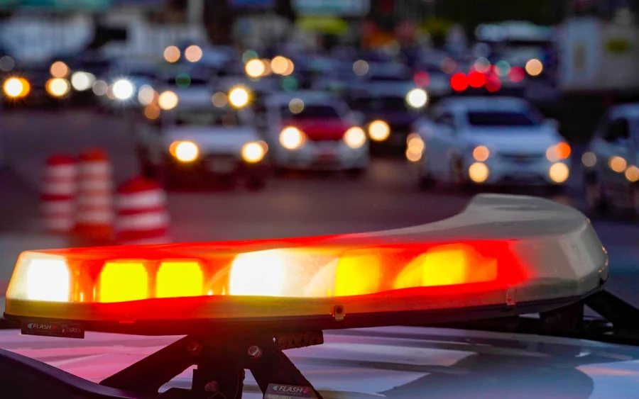 SC tem menor índice de homicídios dos últimos 20 anos, diz SSP Farol de emergência (giroflex) de viatura policial piscando em via movimentada à noite em Santa Catarina, simbolizando o trabalho da Segurança Pública para a redução da violência.