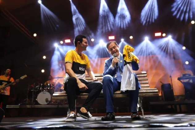 O cantor gospel Leandro Borges no palco do Parque das Nações, em Criciúma, se apresentando para uma multidão de aproximadamente 20 mil pessoas durante a celebração do centenário.