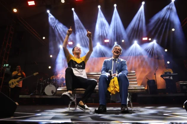 O cantor gospel Leandro Borges no palco do Parque das Nações, em Criciúma, se apresentando para uma multidão de aproximadamente 20 mil pessoas durante a celebração do centenário.