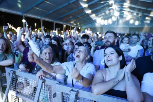 O cantor gospel Leandro Borges no palco do Parque das Nações, em Criciúma, se apresentando para uma multidão de aproximadamente 20 mil pessoas durante a celebração do centenário.