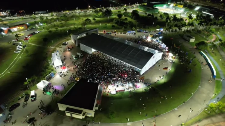 O cantor gospel Leandro Borges no palco do Parque das Nações, em Criciúma, se apresentando para uma multidão de aproximadamente 20 mil pessoas durante a celebração do centenário.