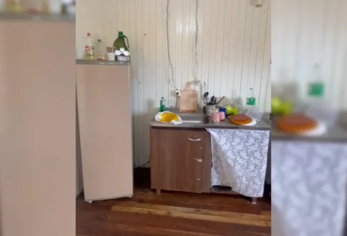 Sombrio Família de refugiada venezuelana precisa de doações Cozinha simples com móveis antigos e paredes de madeira, representando a casa da família refugiada venezuelana que necessita de doações em Sombrio.