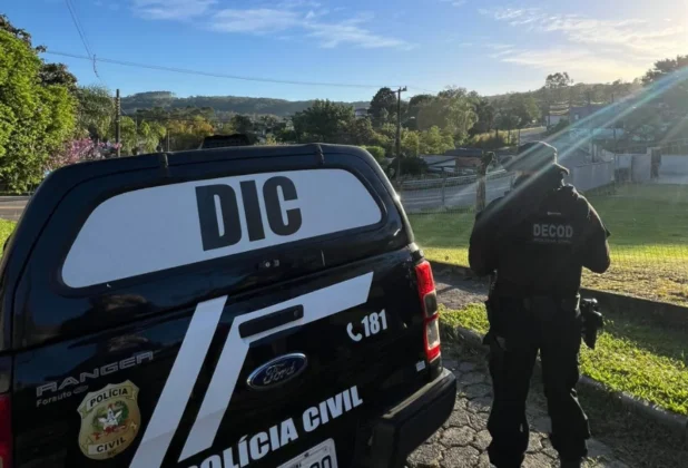 Policial Civil (agente ou delegado) no local da prisão, inspecionando a área após o cumprimento de mandado nos bairros de Criciúma ou Siderópolis.