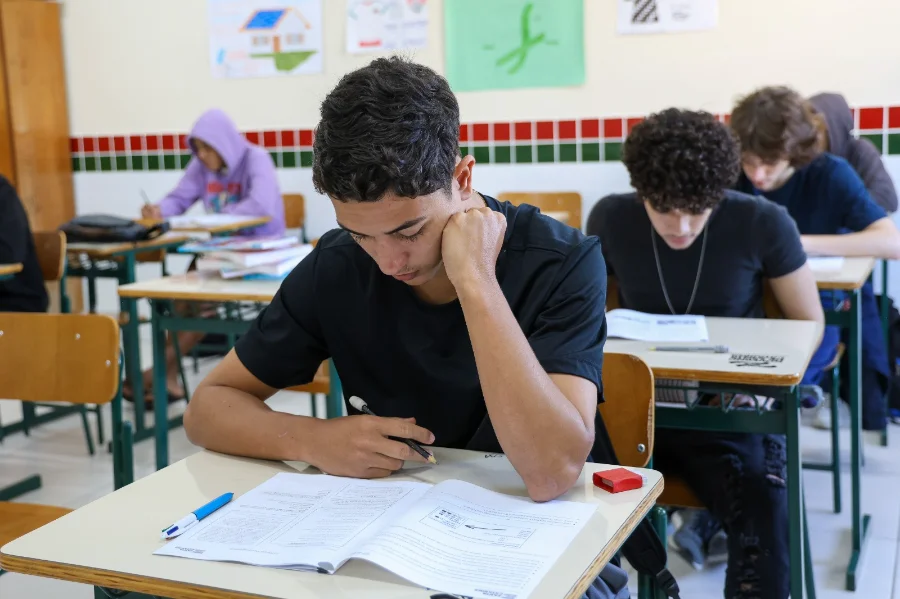 Jovens estudantes em sala de aula, sentados em carteiras e concentrados, ilustrando o prazo de encerramento das transferências na rede estadual de ensino de Santa Catarina.
