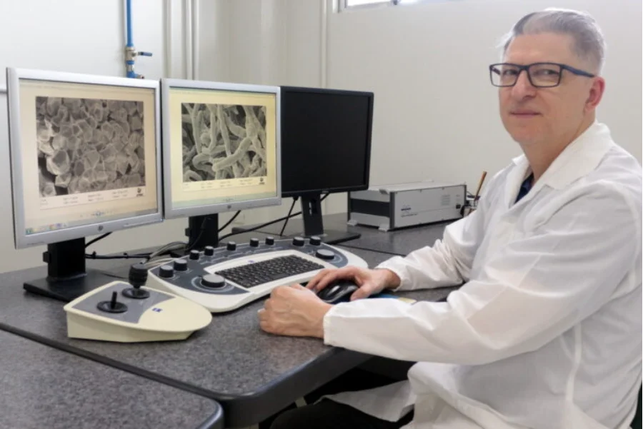 Cientista da UNESC em laboratório, analisando em monitores a microestrutura de material balístico, referente à nova placa de proteção com tecnologia nacional de Criciúma.