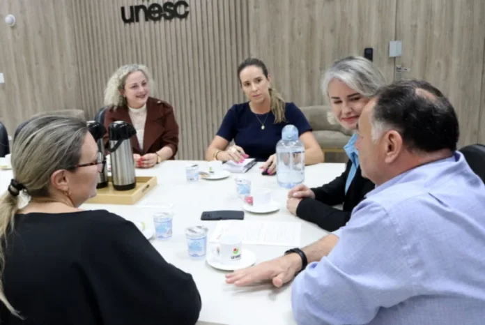 Unesc e Morro da Fumaça articulam parceria para a terceira idade A reitora em exercício da Unesc, Gisele Silveira Coelho Lopes, a primeira-dama Roberta Inocêncio, e a vereadora Marijane Felippe reunidas em uma sala na Unesc, discutindo projetos para a terceira idade.