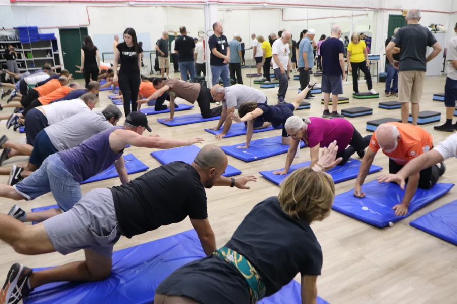 Unesc faz estudo pioneiro com Cannabis para Parkinson Pessoas com Doença de Parkinson realizando exercícios de fisioterapia em grupo, em colchonetes azuis, como parte do estudo pioneiro da UNESC (Criciúma) sobre Cannabis medicinal e exercício físico.