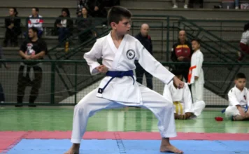 Unesc sedia Copa Criciúma de Karatê com 50 acadêmicos Jovem atleta em quimono branco com faixa azul, executando um golpe (kata) durante a Copa Criciúma de Karatê sediada pela UNESC.