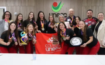 Vôlei feminino de Criciúma garante vaga na Superliga B Jogadoras de vôlei de Criciúma celebrando com medalhas a classificação para a Superliga B, em evento na UNESC.