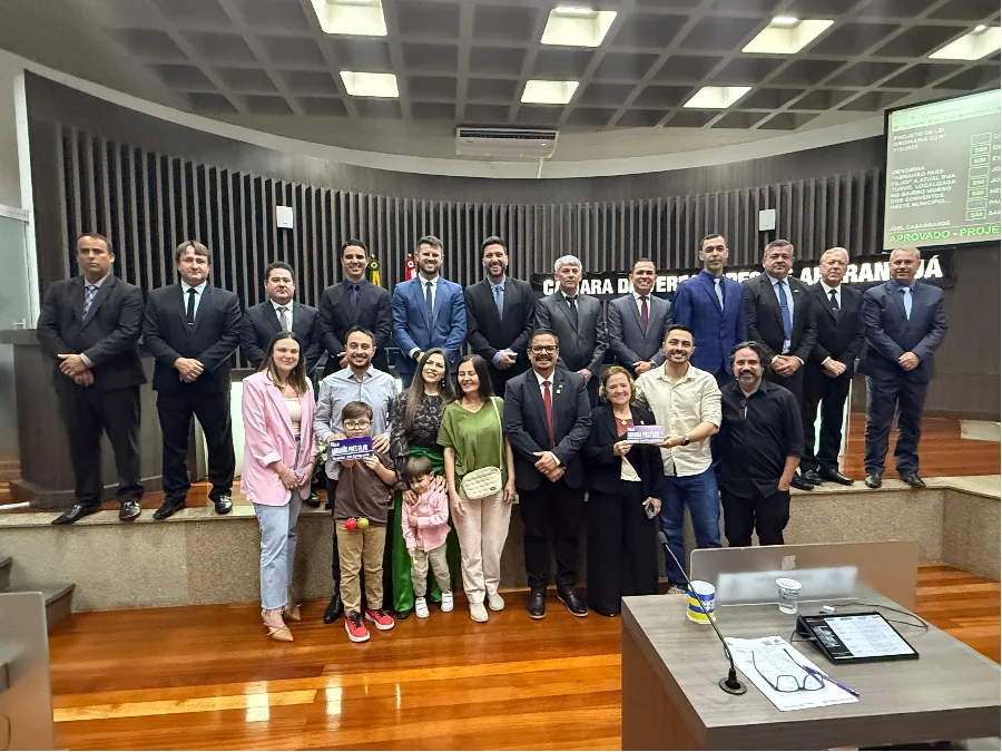 Vereadores da Câmara de Araranguá reunidos com a família de Abrahão Paes Filho, com os filhos e netos segurando a placa de homenagem, após a aprovação do Projeto de Lei que concede o nome do empresário à antiga Rua Turvo.