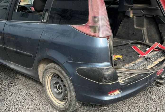 Araranguá_ Criminosos fogem para mata após acidente Traseira do carro Peugeot 206 colidido e abandonado pelos criminosos, com o porta-malas aberto e objetos furtados visíveis, após a fuga em Araranguá.