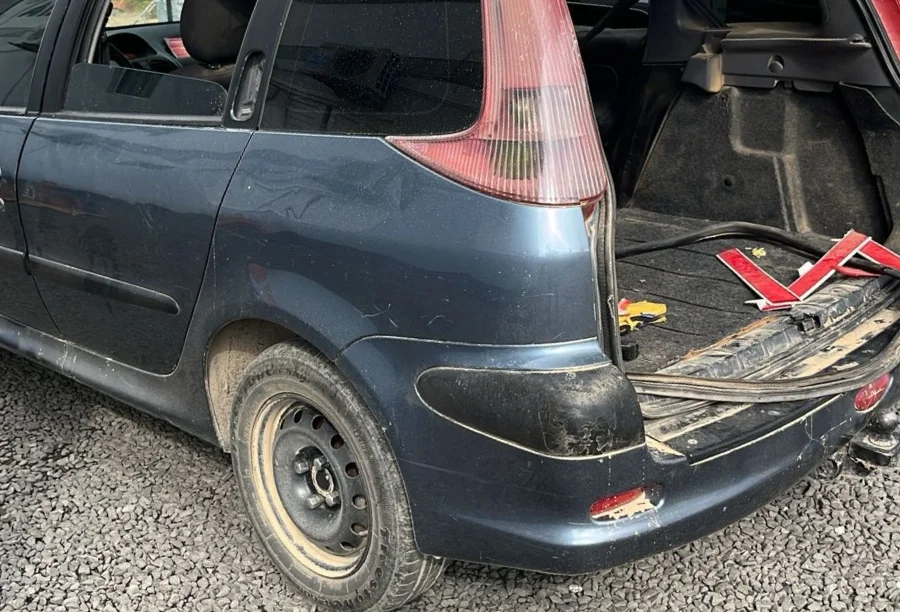 Araranguá_ Criminosos fogem para mata após acidente Traseira do carro Peugeot 206 colidido e abandonado pelos criminosos, com o porta-malas aberto e objetos furtados visíveis, após a fuga em Araranguá.