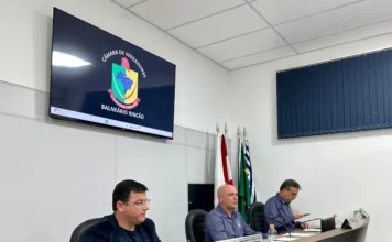 Balneário Rincão aprova direito à merenda para servidores Mesa diretora da Câmara de Vereadores de Balneário Rincão em sessão plenária, com a logo do município no telão, durante a aprovação unânime de projetos como o que garante o direito à merenda para os servidores escolares.