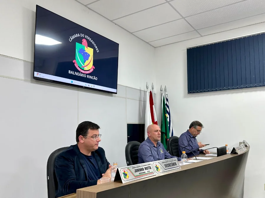 Balneário Rincão aprova direito à merenda para servidores Mesa diretora da Câmara de Vereadores de Balneário Rincão em sessão plenária, com a logo do município no telão, durante a aprovação unânime de projetos como o que garante o direito à merenda para os servidores escolares.