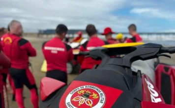Bombeiros iniciam pré-temporada de verão no Litoral Sul Detalhe da parte traseira de um jet ski de resgate do Corpo de Bombeiros Militar de Santa Catarina (CBMSC) com o emblema em destaque, com guarda-vidas em uniformes vermelhos reunidos na areia, marcando o início da pré-temporada da Operação Estação Verão no Litoral Sul.