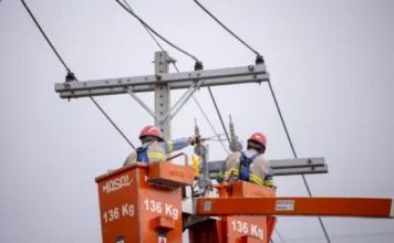 Desligamentos de energia afetam cidades do Litoral Norte do RS Homens arrumando um poste de luz
