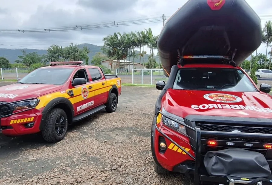 Duas caminhonetes vermelhas de resgate do Corpo de Bombeiros, sendo que uma delas carrega um bote inflável no teto, em Turvo, Santa Catarina.