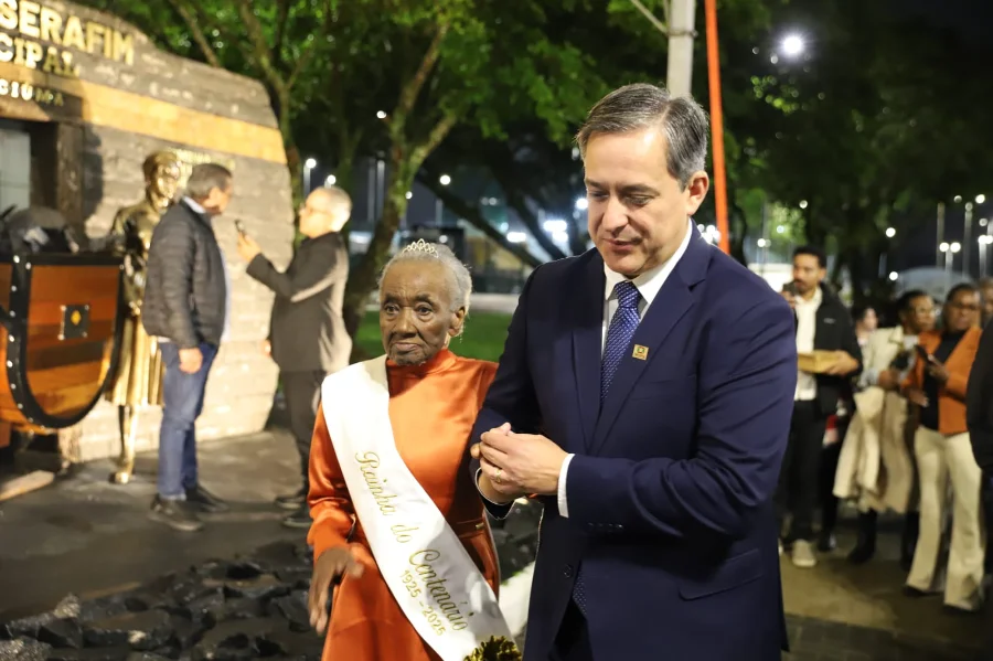 Dona Benta Bittencourt de Assis sendo homenageada pelo Prefeito de Criciúma na cerimônia que celebra o legado dos moradores centenários.