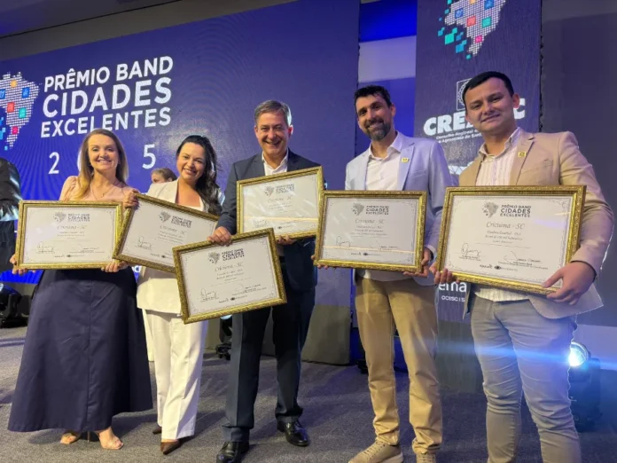 Criciúma vence prêmio estadual de Sustentabilidade Prefeito Vagner Espindola e secretários de Criciúma posando com os troféus do Prêmio Band Cidades Excelentes, após vencer a categoria Sustentabilidade e ser finalista em cinco outras categorias.