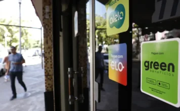 Decreto do PAT limita taxas e busca ampliar concorrência Adesivos de operadoras de vale-alimentação e vale-refeição (Alelo e Green Benefícios) colados na vitrine de um restaurante no Rio de Janeiro, ilustrando o mercado de tíquetes e o novo Decreto do PAT que limita as taxas e visa a interoperabilidade.