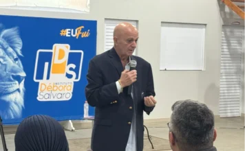 Ex-paciente de câncer relata remissão com método natural Mentor Jimmy Albuquerque, ex-paciente de câncer, discursando com microfone em um seminário no Instituto Débora Salvaro, compartilhando a experiência de remissão da doença com um método natural focado na limpeza do sangue e no poder da fé.