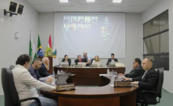 Forquilhinha: Câmara estreia sistema eletrônico de votação Sessão na Câmara de Vereadores de Forquilhinha com vereadores reunidos à mesa e o telão ao fundo exibindo o placar do novo sistema eletrônico de votação, que visa modernizar os trabalhos do Legislativo.